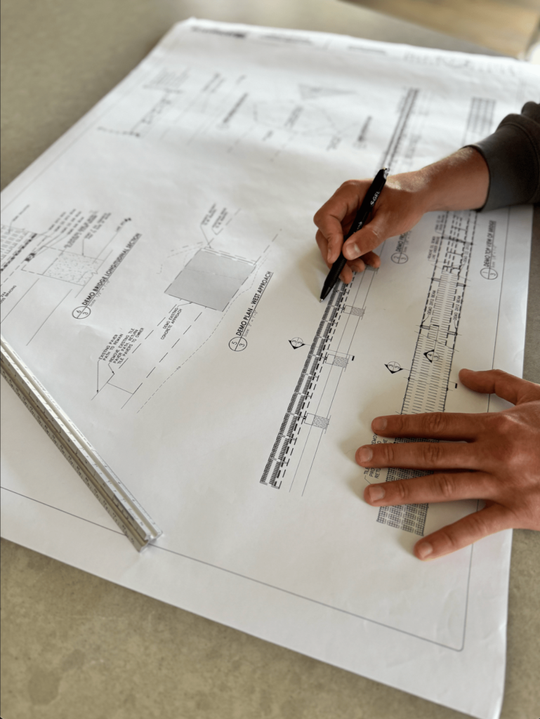 A GRID26 Construction team member reviewing the blueprints of a construction project.