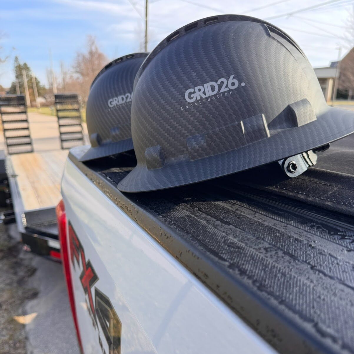 Who We Are-min Two GRID26 hardhats sitting on the back of a truck.